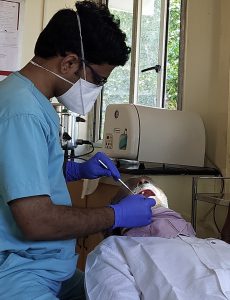 Examining a mans mouth in the dental chair at CMC Vellore Chittoor 