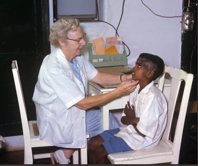Ida b sits in clinic and examines a young boy