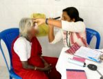 A docor checks the eyes of an old lady at the CONCH community clinic