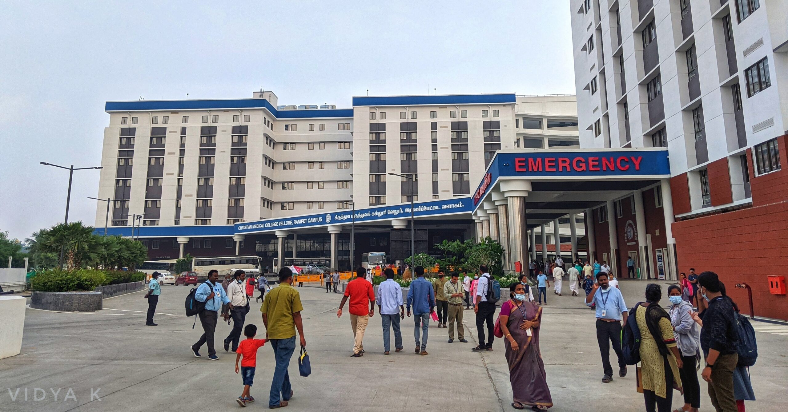 front of hospital with staff and patients and emergency entrance sign